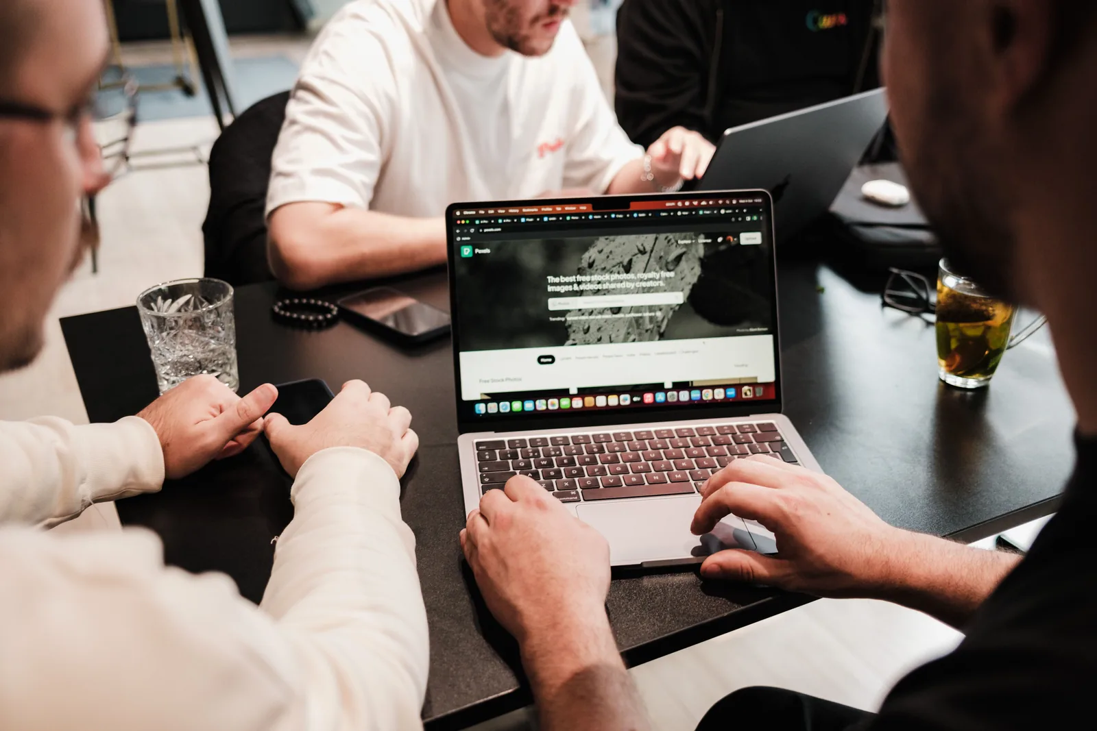 Profesionales colaborando alrededor de equipos tecnológicos